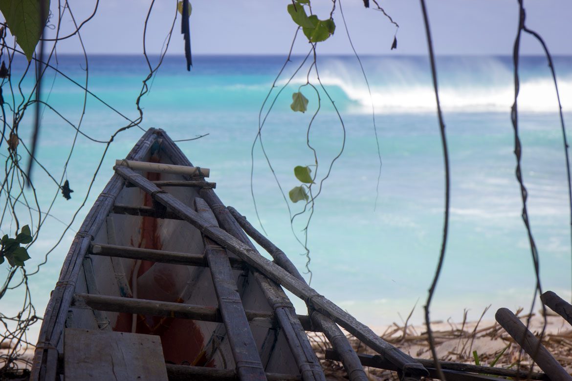 Traditional fishing canoe with wave in the background