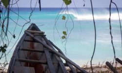 Traditional fishing canoe with wave in the background